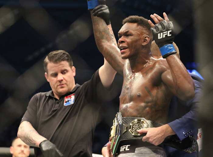Israel Adesanya (blue gloves) defeats Robert Whittaker (red gloves) during UFC 243 at Marvel Stadium.